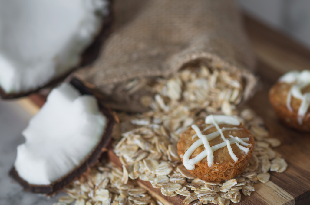 3Leaf Coconut Oatmeal Cookie is placed on top of natural ingredients like rolled oats and chunks of coconut.