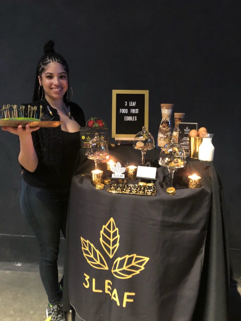 A 3Leaf team member hands out samples of edibles at an event.